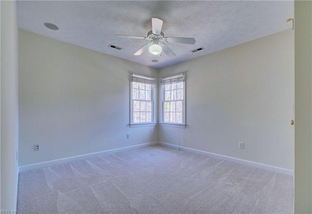 carpeted empty room with visible vents, baseboards, a textured ceiling, and ceiling fan