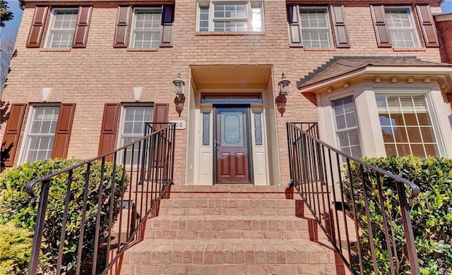 entrance to property featuring brick siding