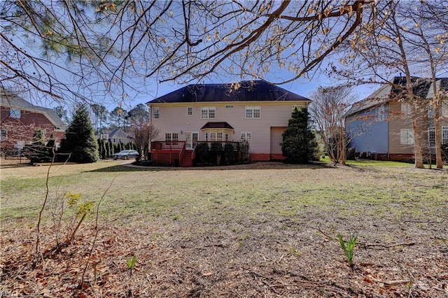 rear view of house featuring a lawn and a wooden deck