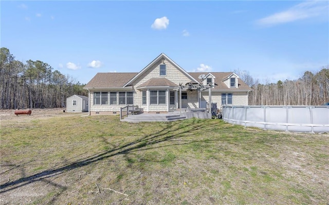 back of property with a lawn, an outdoor pool, a sunroom, and crawl space