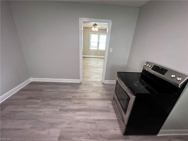 clothes washing area with wood finished floors and baseboards