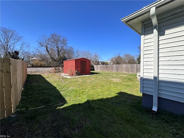 view of yard featuring a fenced backyard, a storage shed, and an outdoor structure