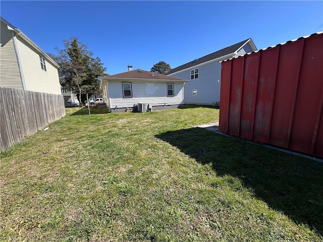 view of yard with central air condition unit and fence