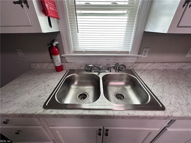 details with light countertops, a fire extinguisher, and a sink