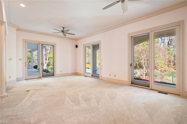 carpeted spare room with a healthy amount of sunlight, baseboards, a ceiling fan, and ornamental molding