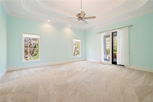 spare room with carpet flooring, baseboards, crown molding, and a tray ceiling