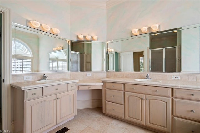 bathroom with two vanities, a shower stall, crown molding, and a sink