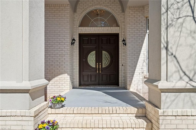 entrance to property featuring brick siding