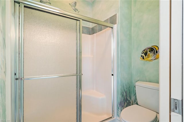 bathroom featuring toilet and a shower stall