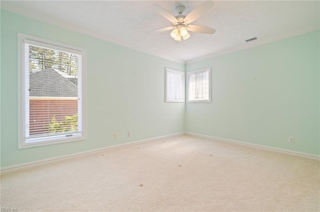 unfurnished room with a wealth of natural light, carpet flooring, and a ceiling fan