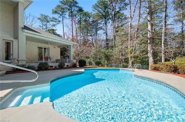 outdoor pool with a patio area and ceiling fan