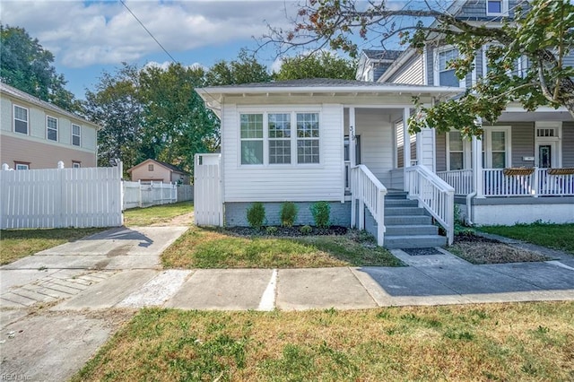 view of front of home featuring a porch and fence