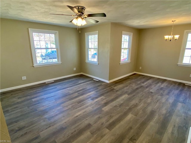 spare room featuring baseboards, dark wood-type flooring, and ceiling fan with notable chandelier