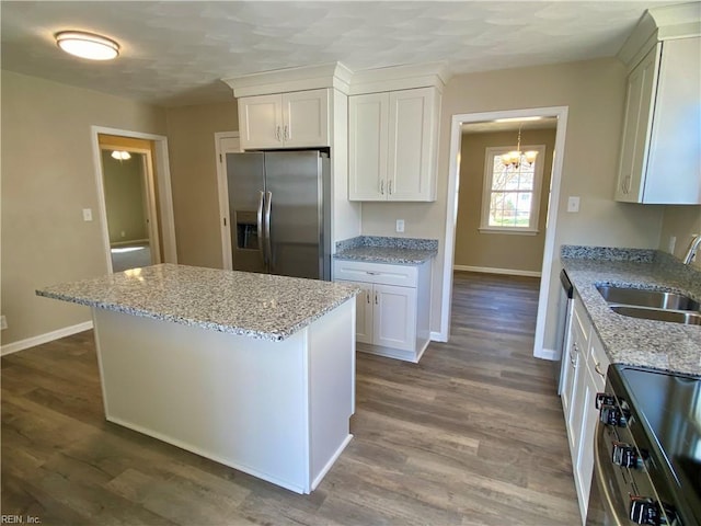 kitchen with a sink, a center island, dark wood finished floors, and stainless steel appliances