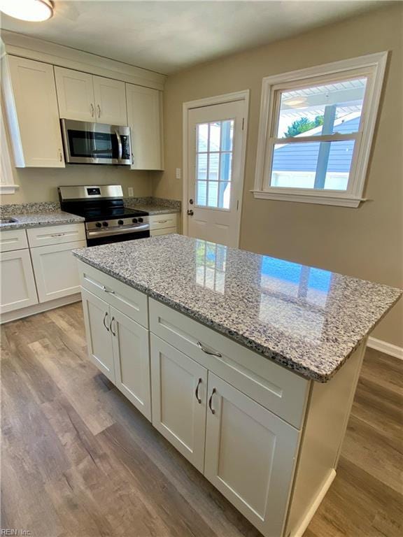 kitchen featuring white cabinets, a center island, light wood-type flooring, and stainless steel appliances