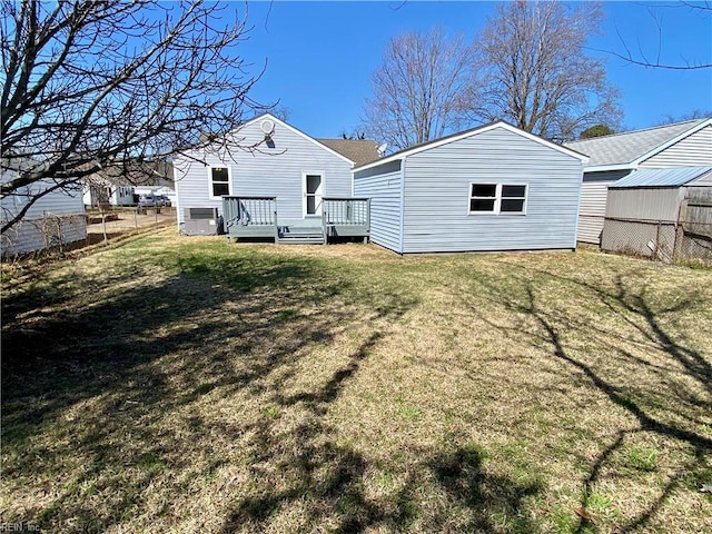 back of house featuring a yard, central AC, a deck, and fence