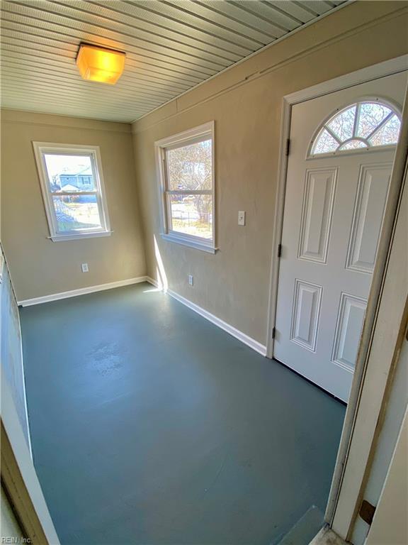 foyer entrance featuring baseboards and finished concrete flooring