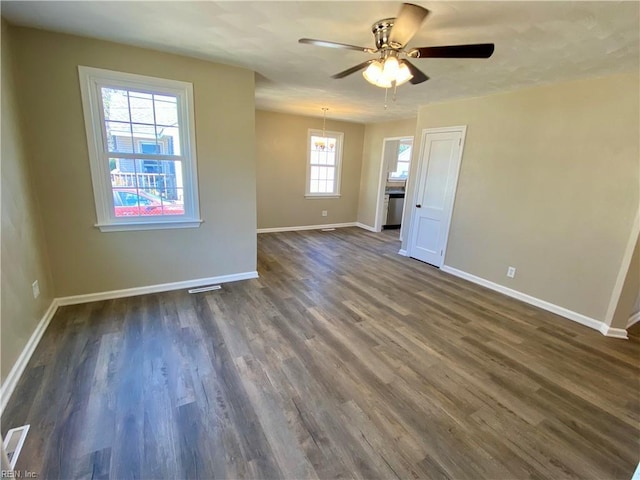 spare room featuring visible vents, baseboards, dark wood finished floors, and a ceiling fan