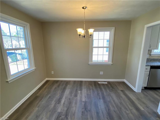 unfurnished dining area featuring a notable chandelier, visible vents, baseboards, and dark wood-style flooring