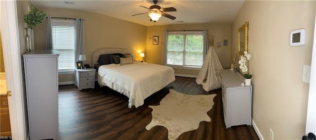 bedroom with a ceiling fan, dark wood-type flooring, and baseboards