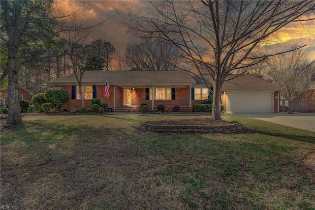 ranch-style home with a front yard, brick siding, a garage, and driveway