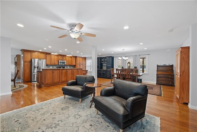 living area with recessed lighting, light wood-style flooring, and baseboards