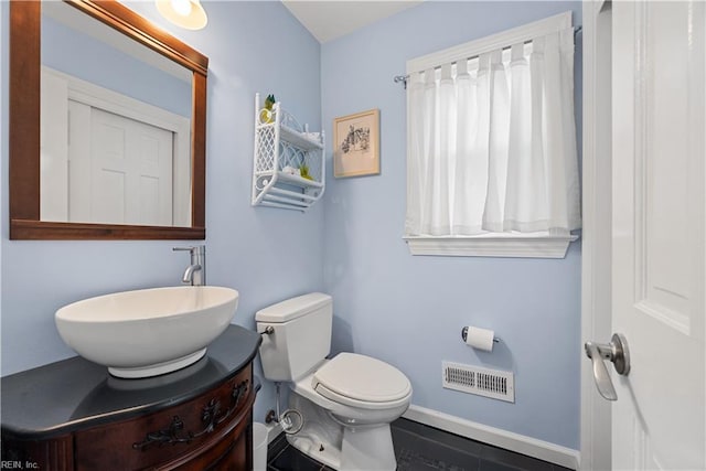 bathroom featuring vanity, toilet, baseboards, and visible vents