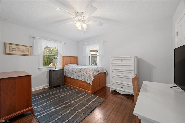 bedroom featuring visible vents, a ceiling fan, a textured ceiling, dark wood finished floors, and baseboards