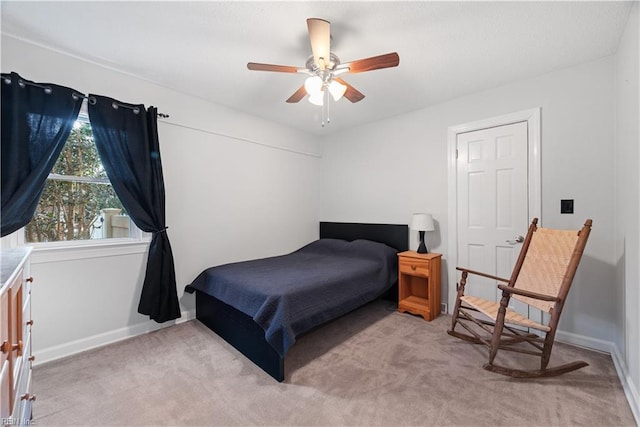 bedroom with light colored carpet, baseboards, and ceiling fan