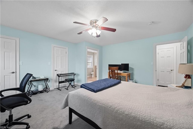 carpeted bedroom featuring connected bathroom, a ceiling fan, baseboards, and a textured ceiling