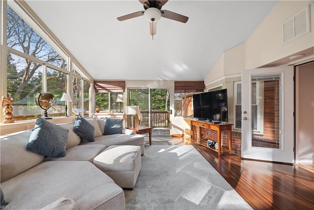 sunroom with lofted ceiling, visible vents, and ceiling fan