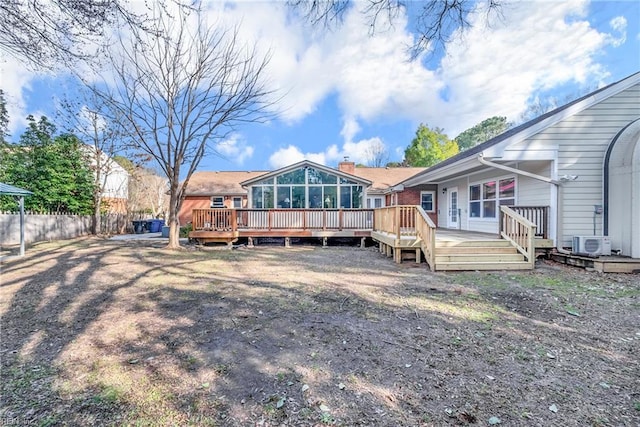 back of house with a sunroom, a deck, and fence