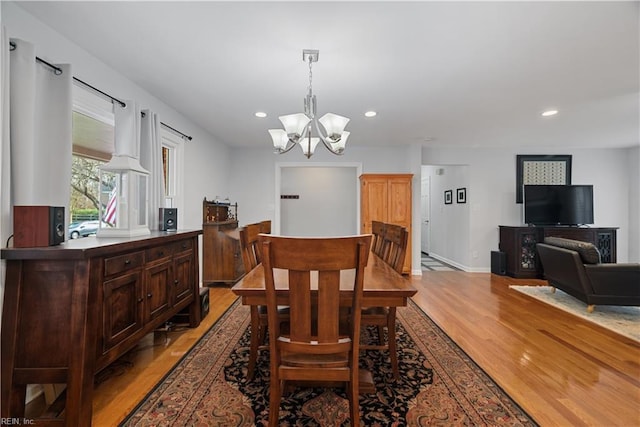 dining space featuring recessed lighting, a notable chandelier, light wood-style flooring, and baseboards