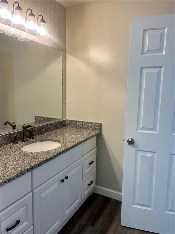 bathroom with vanity, baseboards, and wood finished floors