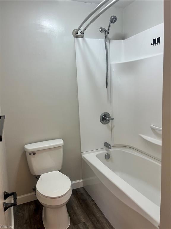 full bathroom with toilet, baseboards, and wood finished floors