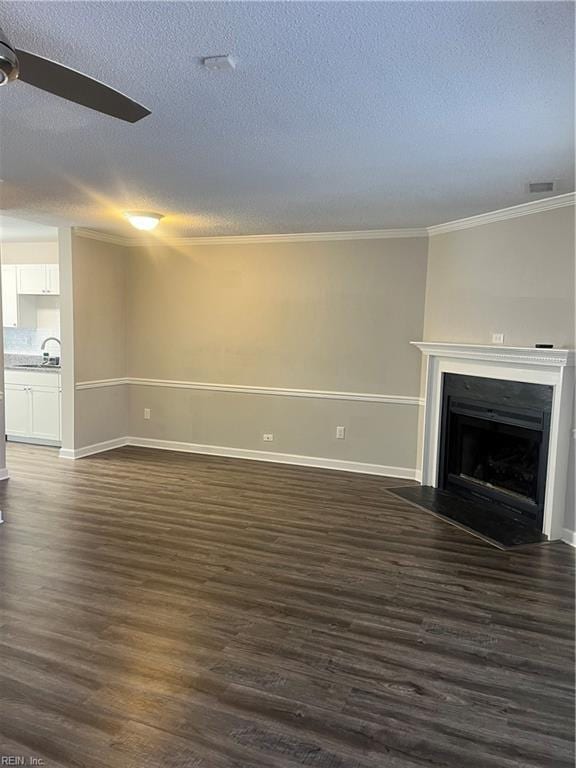 unfurnished living room featuring baseboards, ceiling fan, dark wood finished floors, a fireplace with flush hearth, and a textured ceiling