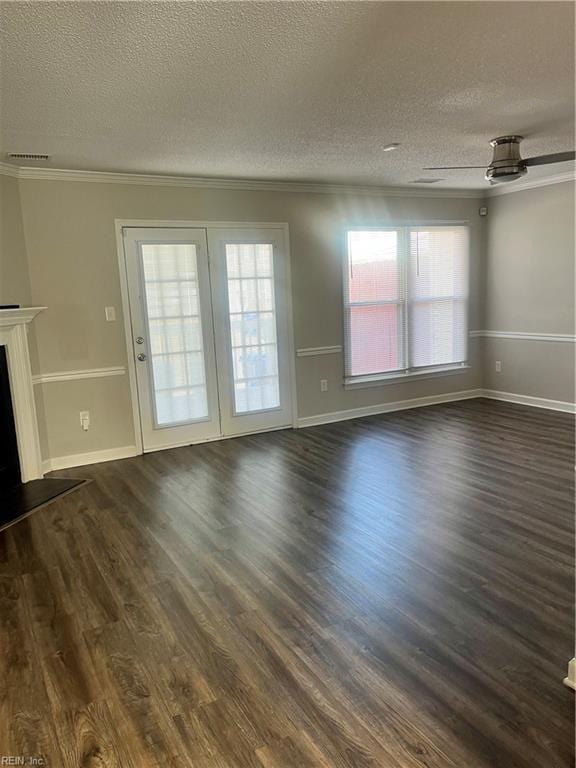 unfurnished living room with a healthy amount of sunlight, dark wood finished floors, a fireplace, and crown molding