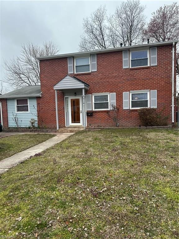 traditional home with a front yard and brick siding