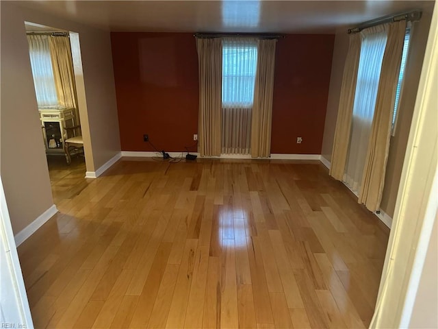 empty room with light wood finished floors and baseboards