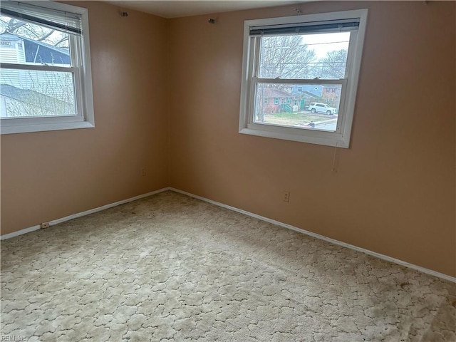 unfurnished room featuring plenty of natural light and baseboards