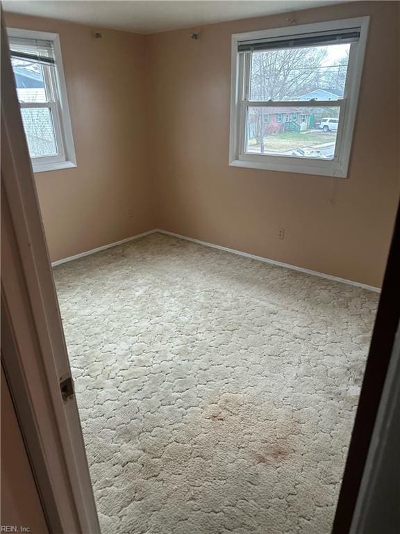 empty room featuring baseboards and plenty of natural light