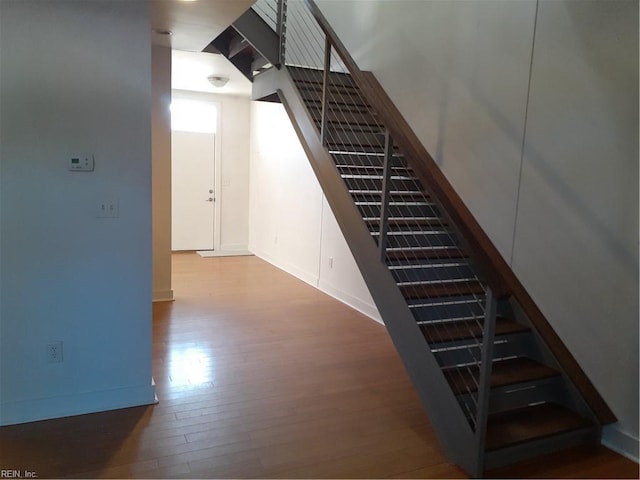 staircase with baseboards and wood finished floors