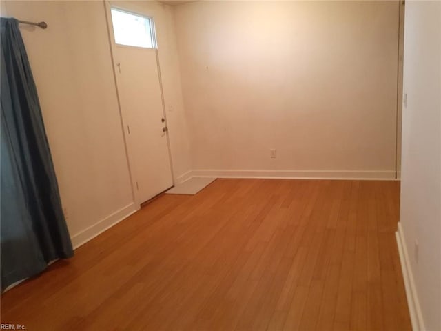 unfurnished room with baseboards and light wood-style floors