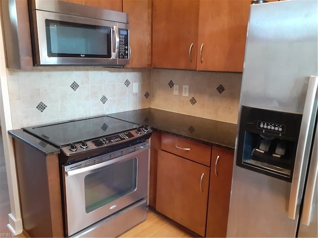 kitchen featuring tasteful backsplash, appliances with stainless steel finishes, and brown cabinetry