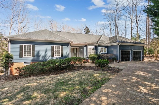 ranch-style house featuring aphalt driveway, roof with shingles, and an attached garage