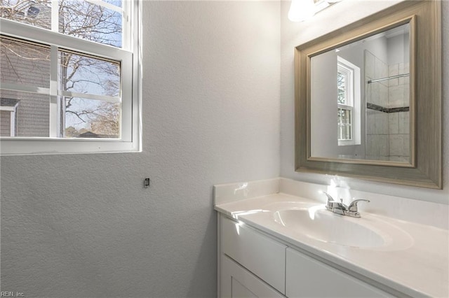 bathroom with vanity and a textured wall