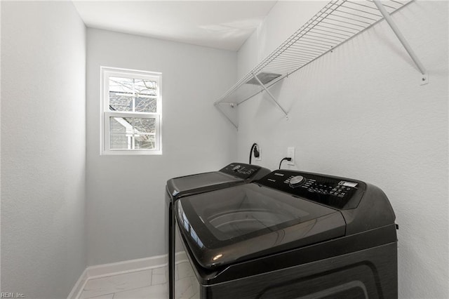 clothes washing area with laundry area, baseboards, marble finish floor, and washer and clothes dryer