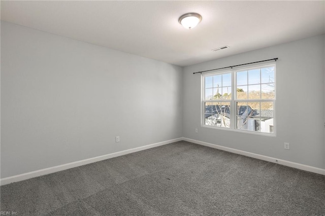 spare room with visible vents, baseboards, and carpet