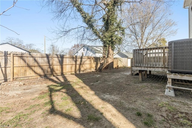 view of yard with central air condition unit, a fenced backyard, and a deck