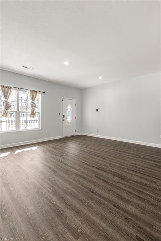 unfurnished living room with visible vents, recessed lighting, dark wood-type flooring, and baseboards